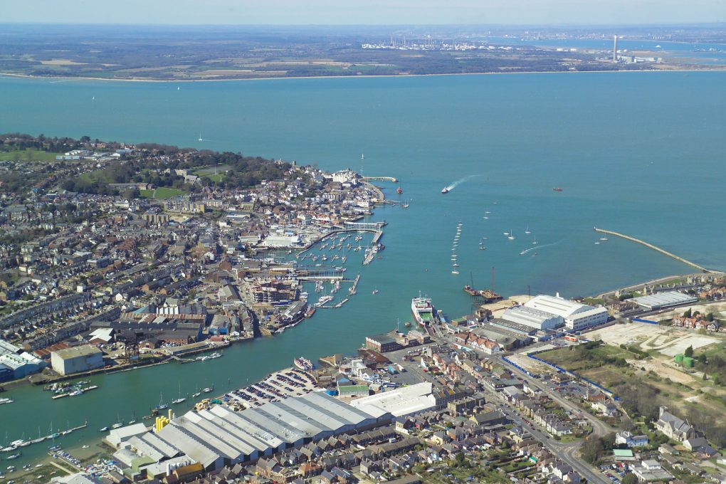 Overhead photograph of a coastal town with buildings and industry.