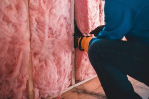Photograph of person installing wall insulation