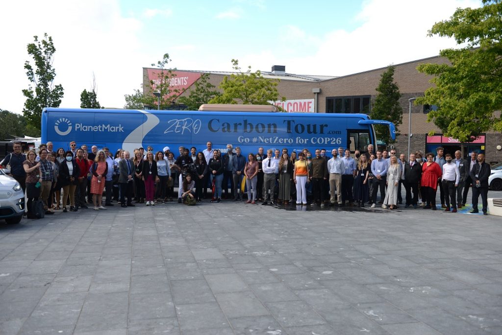 Photograph of a group of people stood together in front of an ECO Bus