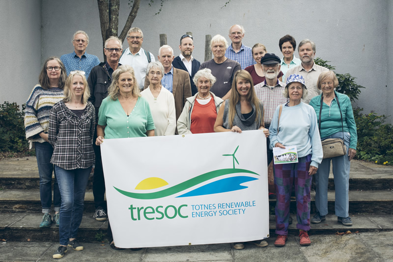 Photograph of a group of people holding a large sign showing a tresoc logo