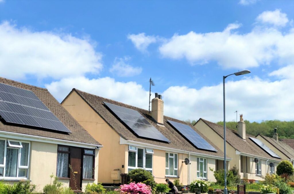 photograph of houses fitted with solar panels on their roofs